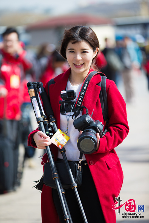 2016年兩會(huì)，人民大會(huì)大堂前，一位笑容燦爛的紅衣女記者正步入大會(huì)堂。中國(guó)網(wǎng) 鄭亮 攝