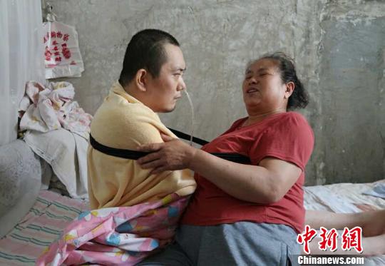 身體日漸衰老的梁青蘭每次幫兒子翻身、坐立，全身的衣物都要濕透一次?！∩忻鱾b 攝