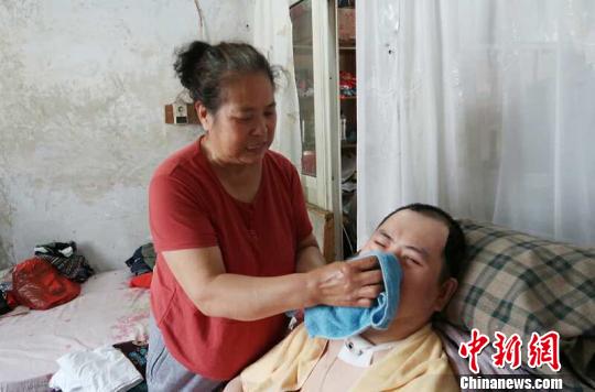 每次喂完食物后，梁青蘭都要仔細(xì)地幫兒子清理干凈?！∩忻鱾b 攝