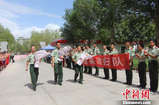 部隊官兵們迎接出院歸來的李運飛(中)和其他消防戰(zhàn)士?！⊥粲?攝