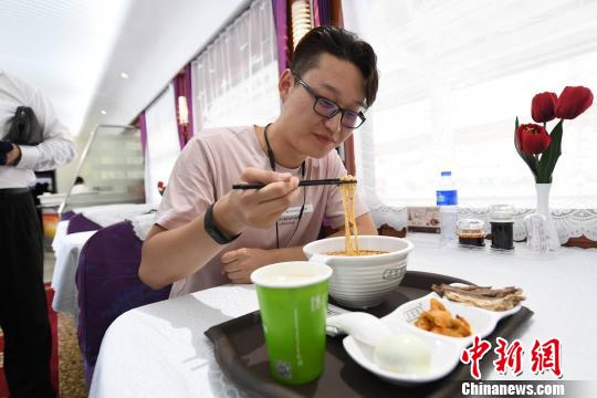 圖為旅客在列車上享用正宗牛肉面?！钇G敏 攝